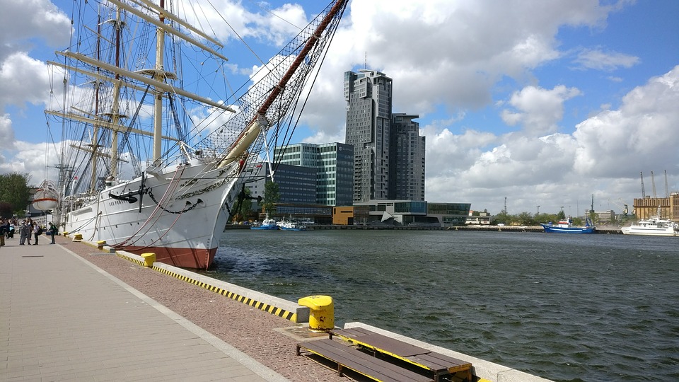 Gdynia. Żaglowiec Dar Pomorza przy nabrzeżu. W tle wysokie budynki.